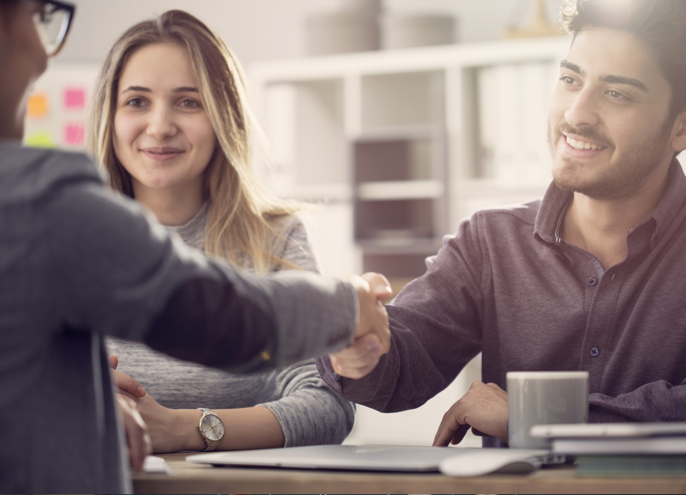 three people and a handshake